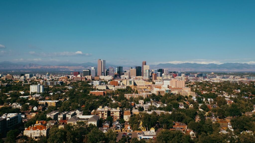Aerial drone view of the downtown Denver skyline on a clear summer day with the Rocky Mountains in the distance