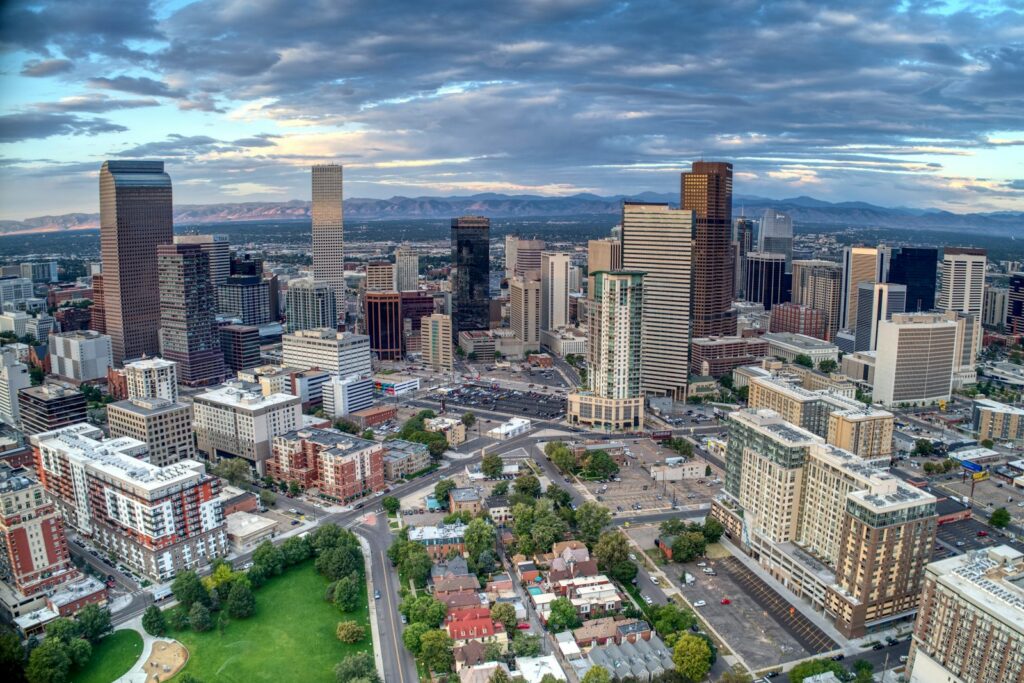 Downtown Denver at daybreak with the Rocky Mountains behind