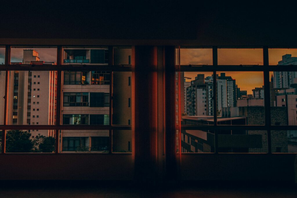 City apartment towers seen through an apartment window at sunset