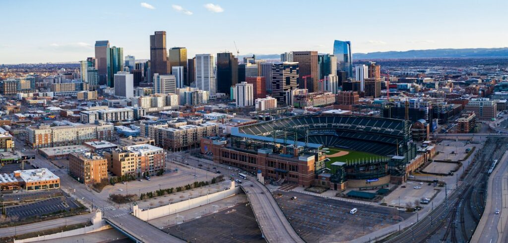 Aerial panorama of Denver roads and a ballpark at rush hour