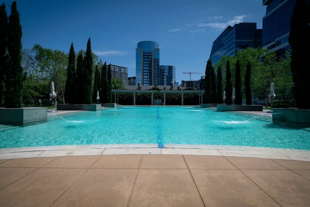 Apartment pool surrounded by trees and high-rise buildings