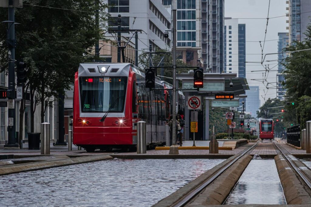 Red light-rail train on city tracks