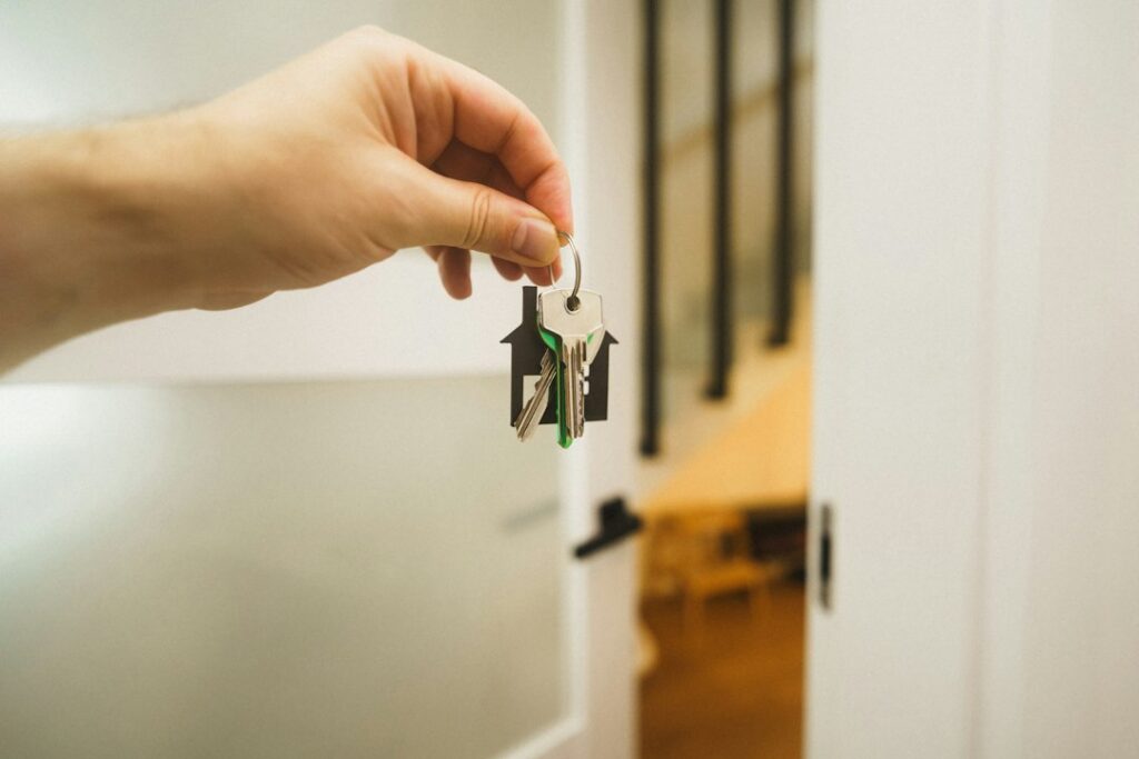 Hand holding the keys to a new home at an open front door