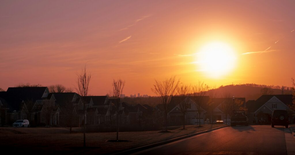Sunset over Nashville neighborhoods with the downtown skyline behind